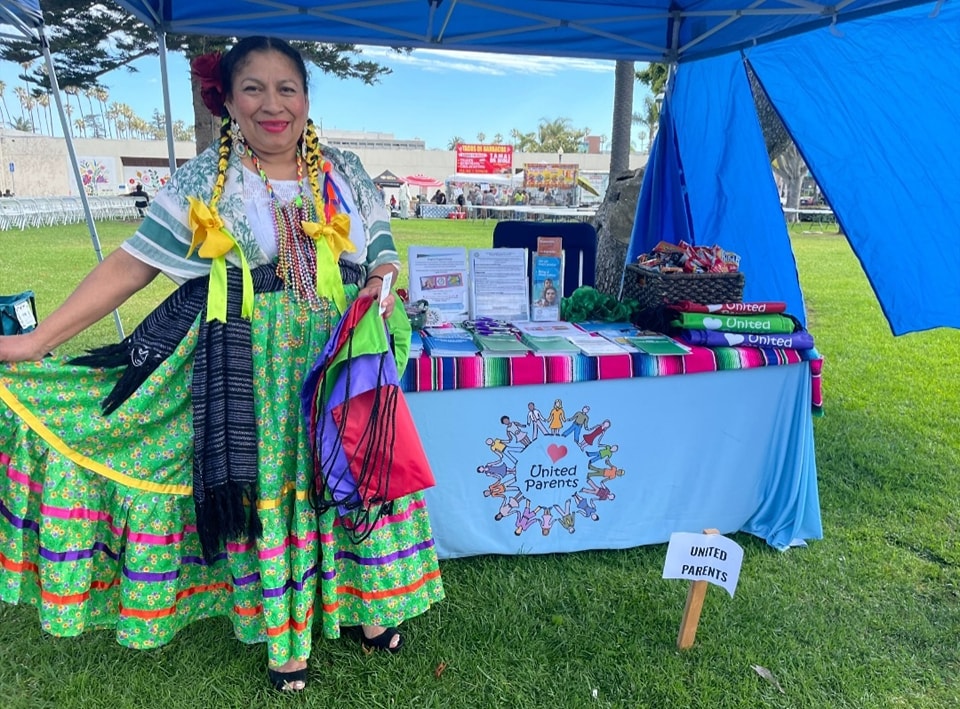 Woman in cultural garb at United Parents stand