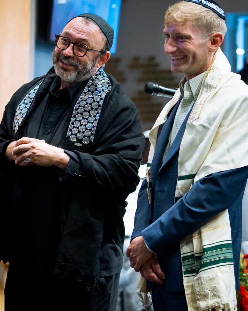 Two smiling men wearing Kippahs standing side by side 