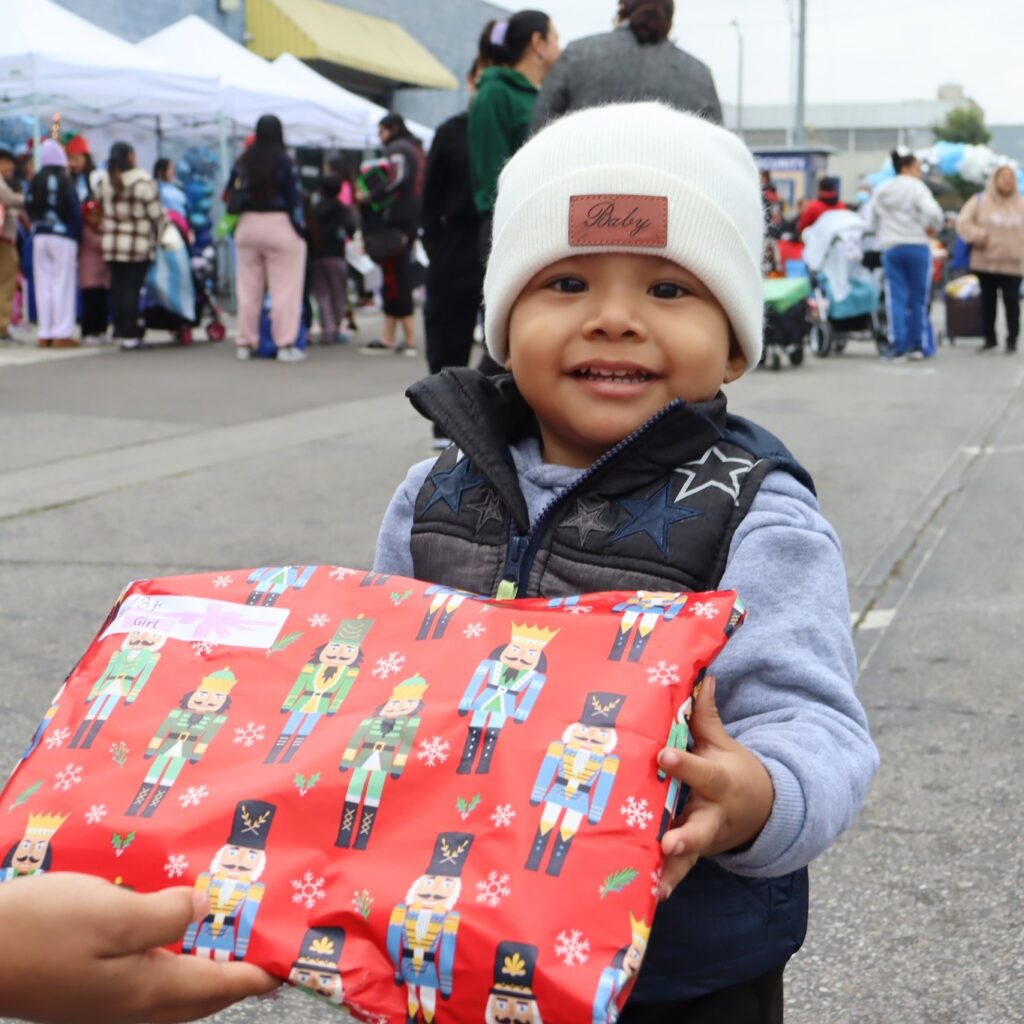 Child outside receiving wrapped gift