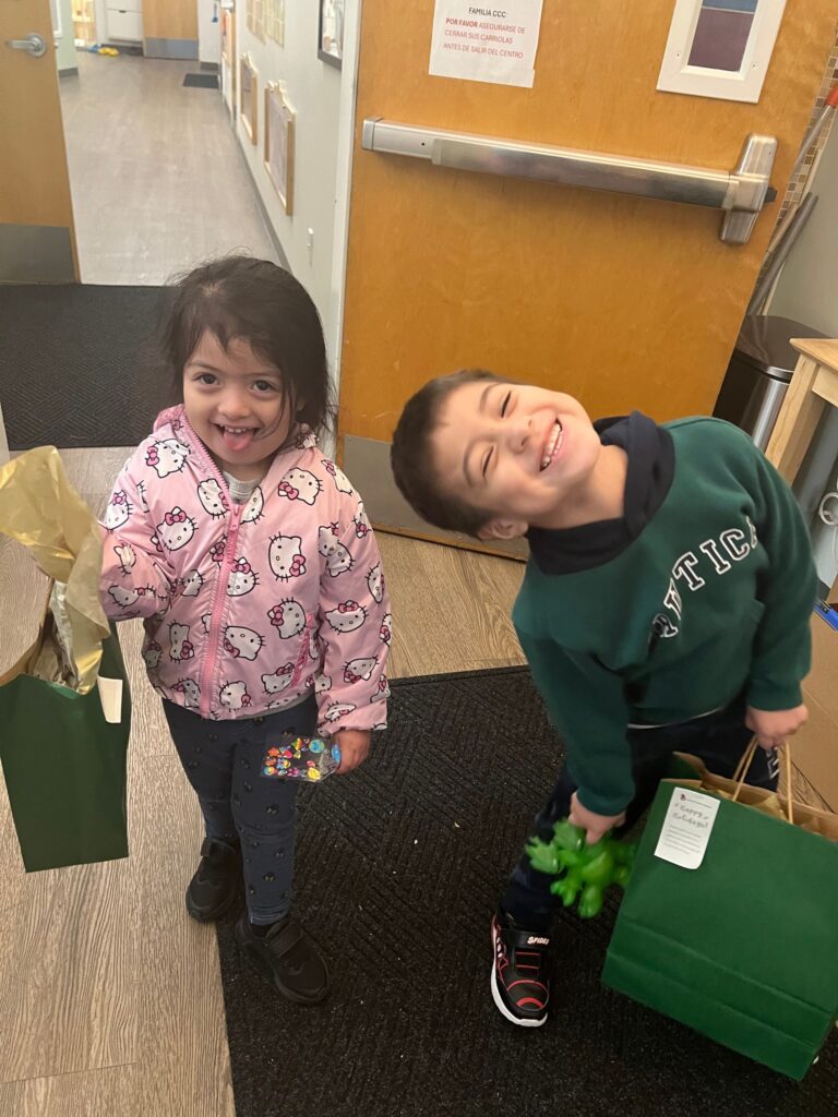 Young boy and girl smiling holding gift bags