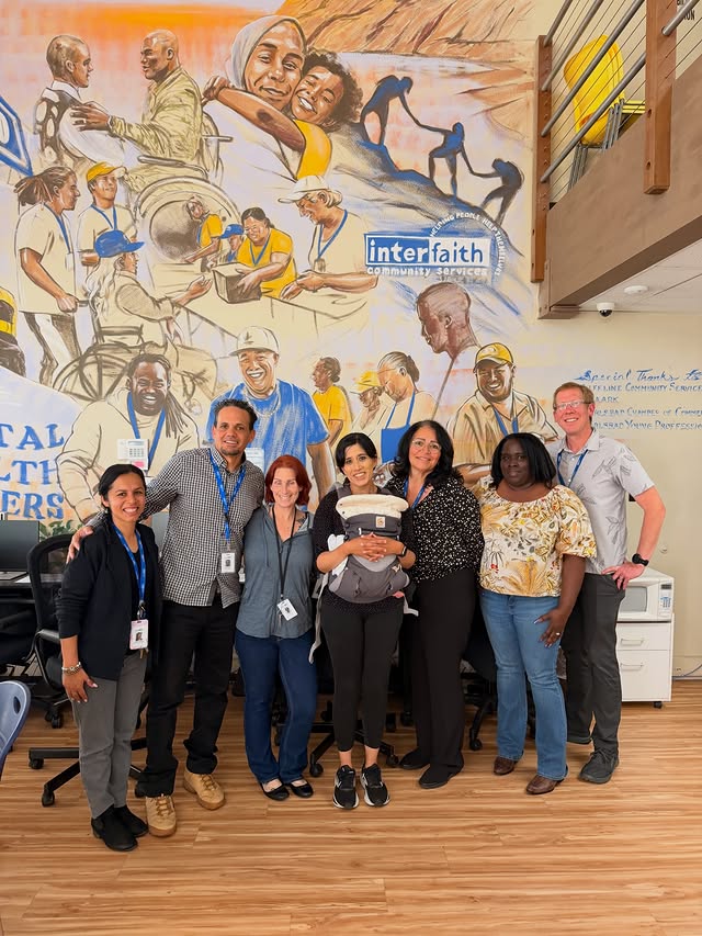 Group of people from Interfaith Community Services in front of mural