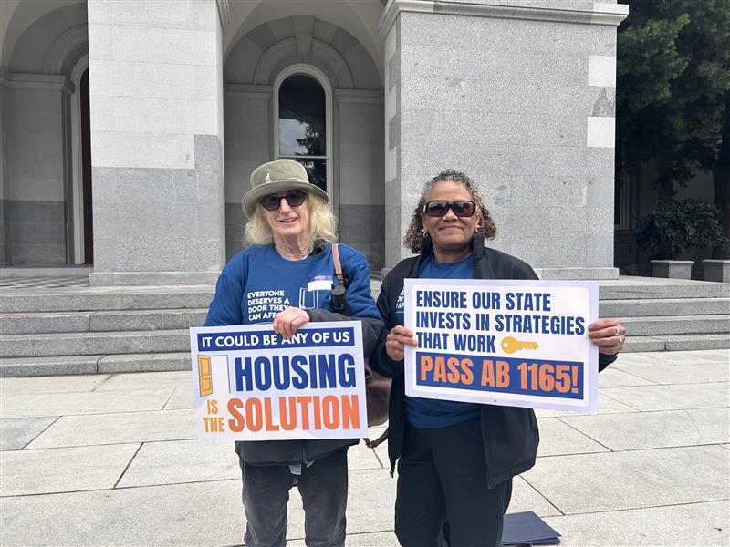 Two women holding Supportive Housing signs
