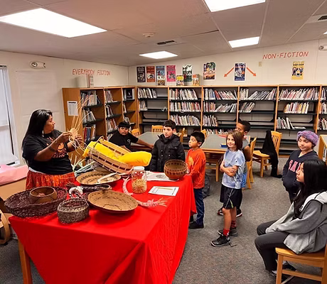 Woman teaching basket weaving to a group of kids