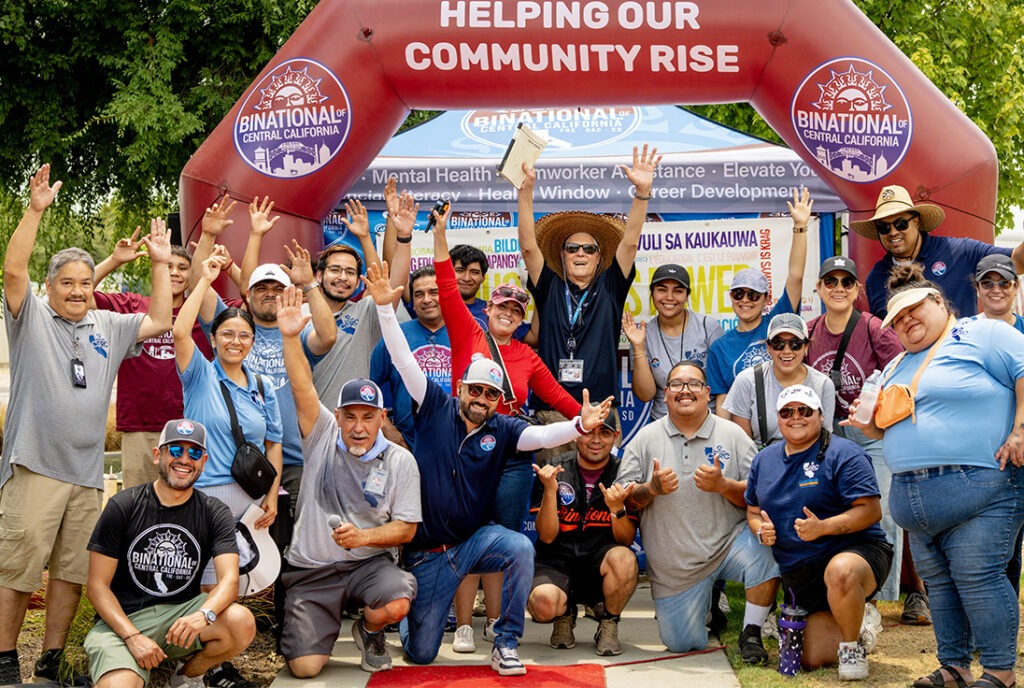 Large group of people with there hands up at a Binational of Central California event