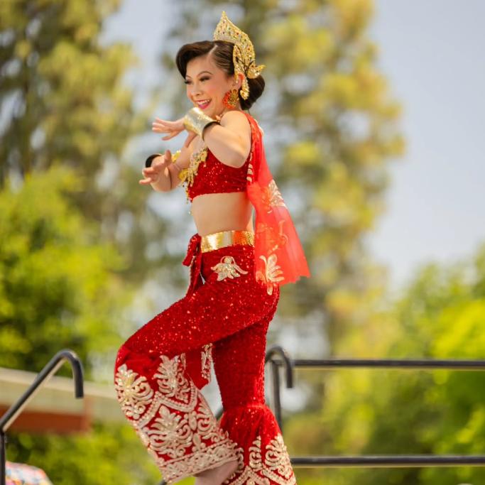 Woman dancing in glittering red and gold clothing