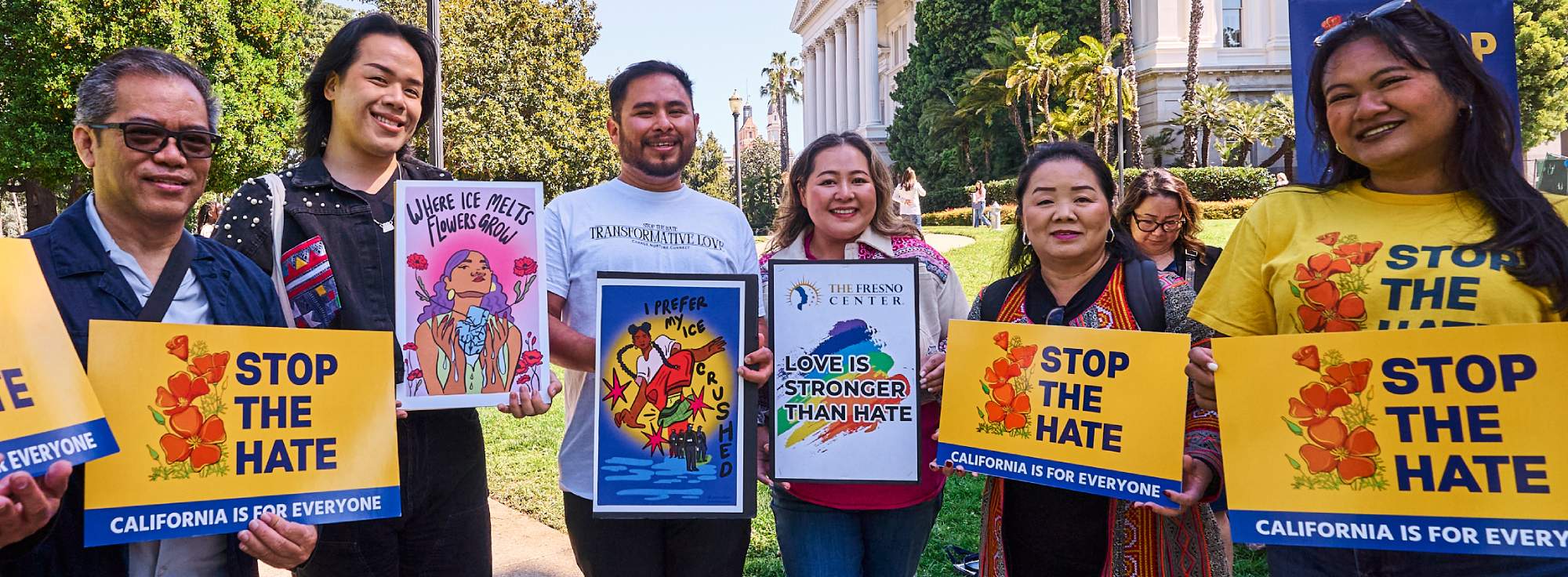Group of people holding Stop The Hate signs in front of the California State Capitol