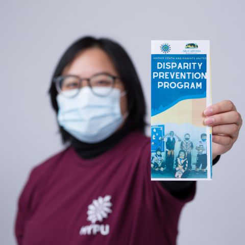 Woman holding Disparity Prevention Program pamphlet